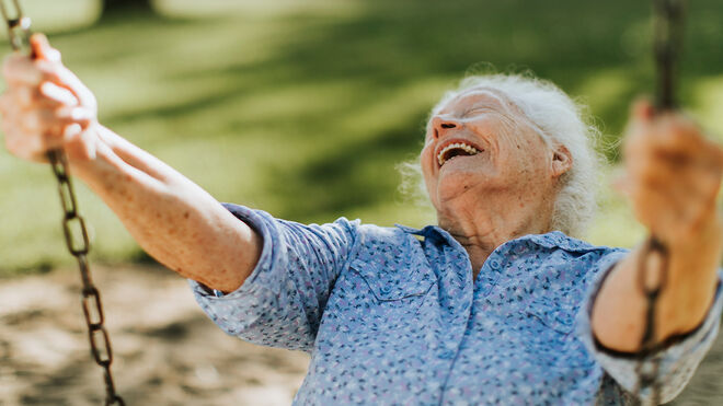 Fröhliche Seniorin auf einer Schaukel | gettyimages / Rawpixel